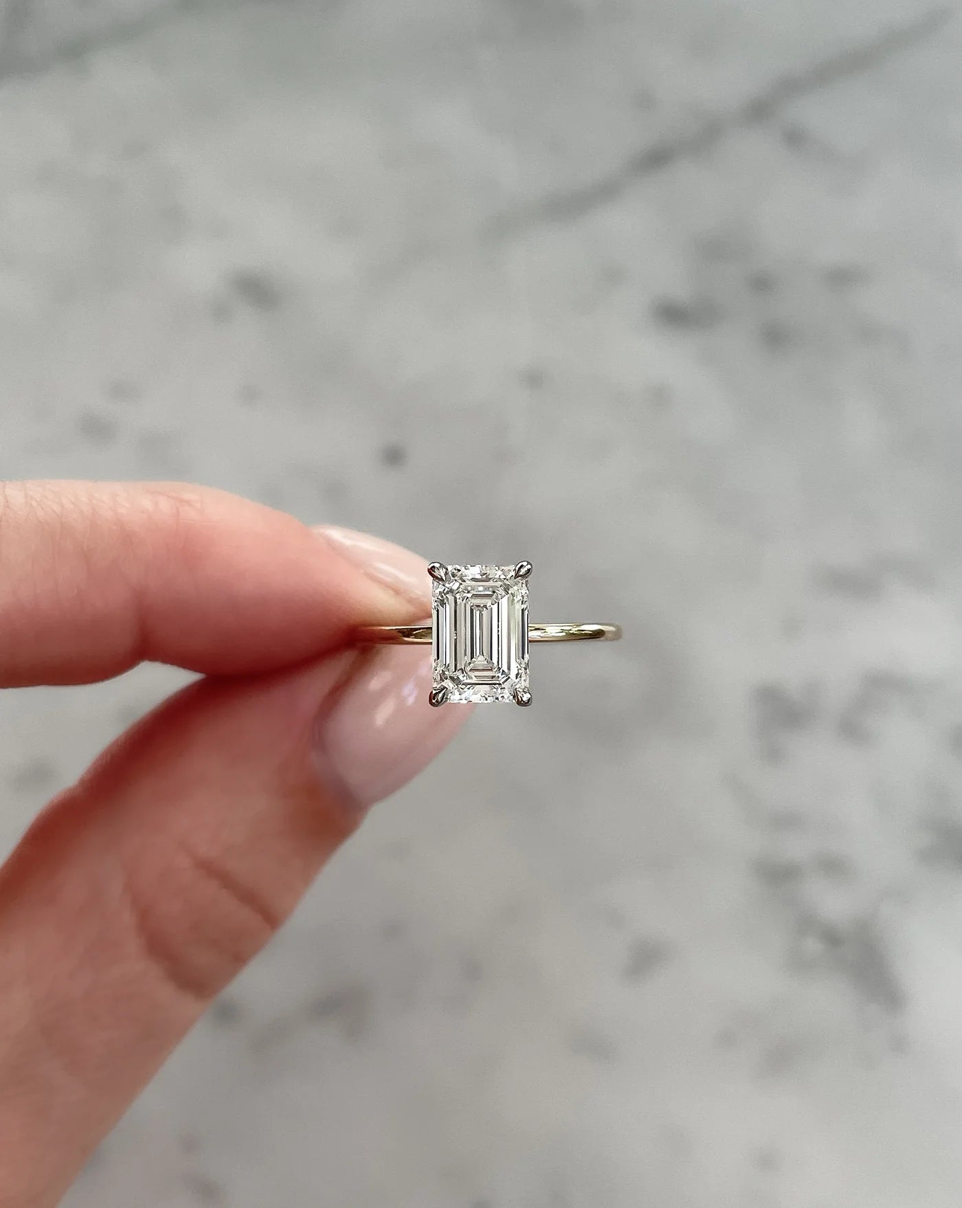 2 carat emerald cut lab diamond solitaire ring set in 14kt hallmark yellow gold band. The ring shows exceptional cut and is in a classic 4 prong setting.