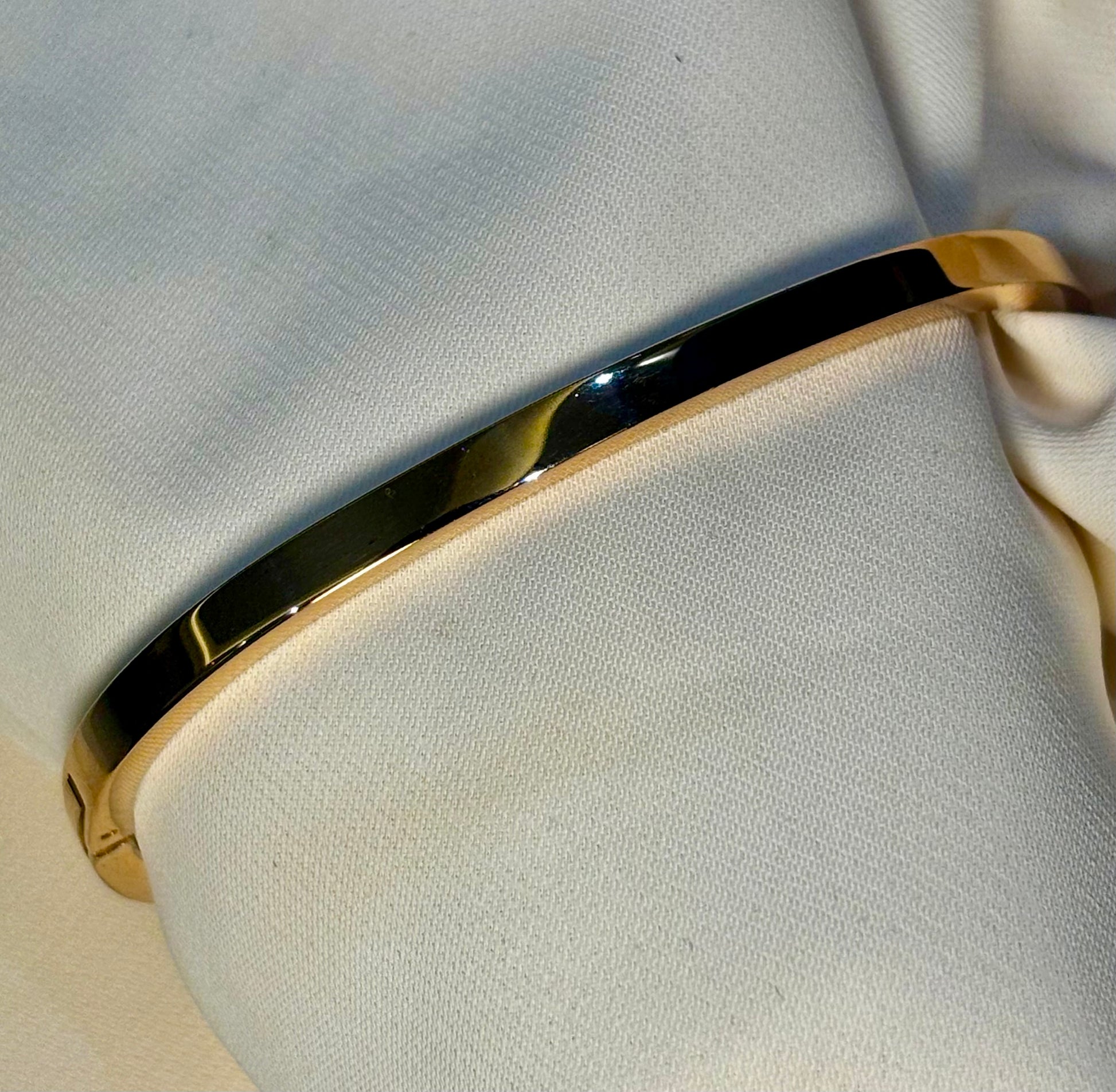 Sleek, half eternity rose gold tone bangle made with 92.5 sterling silver and 18 carat rose gold plating. Anti tarnish and waterproof.
