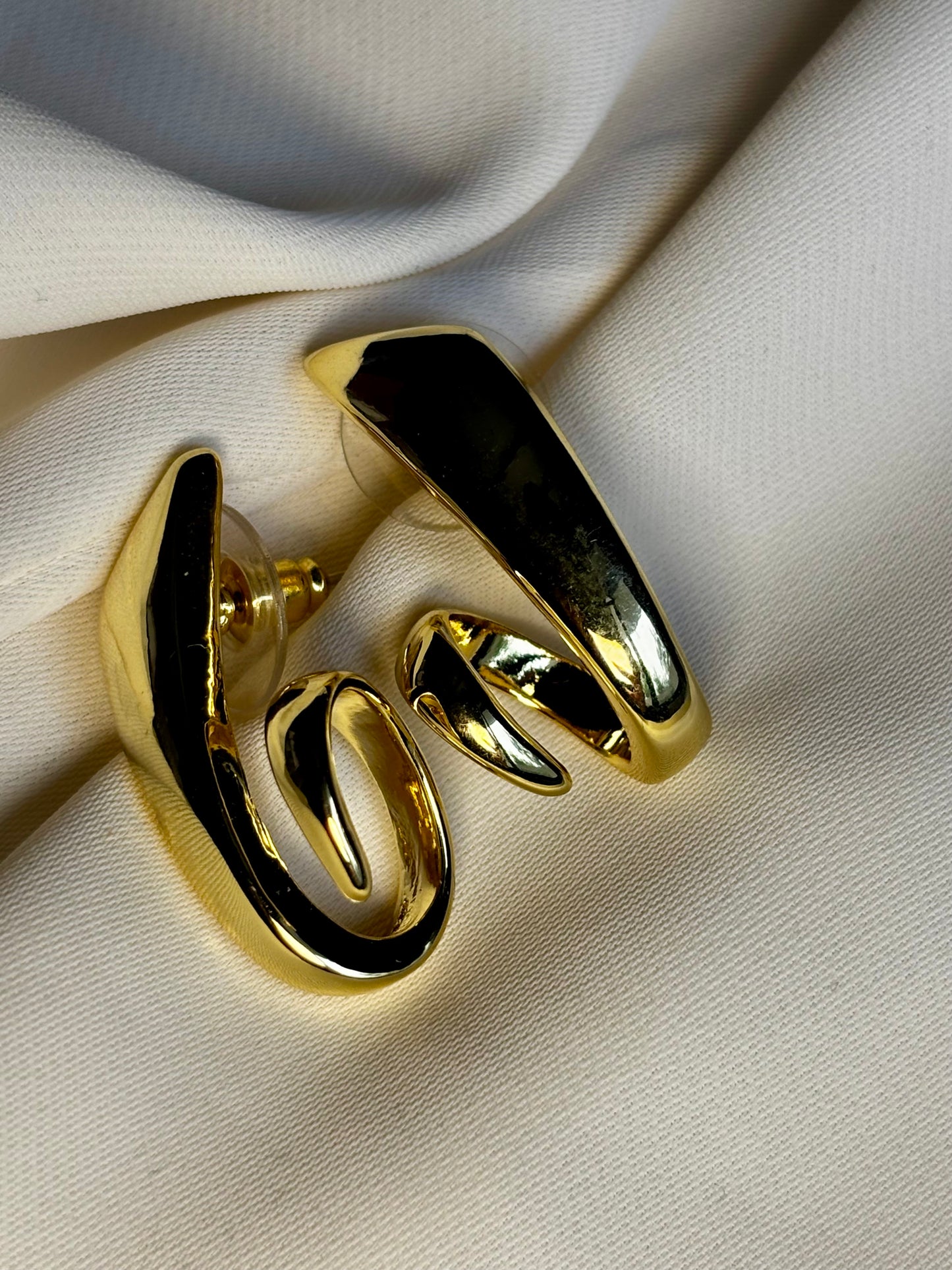 Sculpted twist earrings made with 92.5 sterling silver in 18 karat gold plating. Anti- tarnish and waterproof.