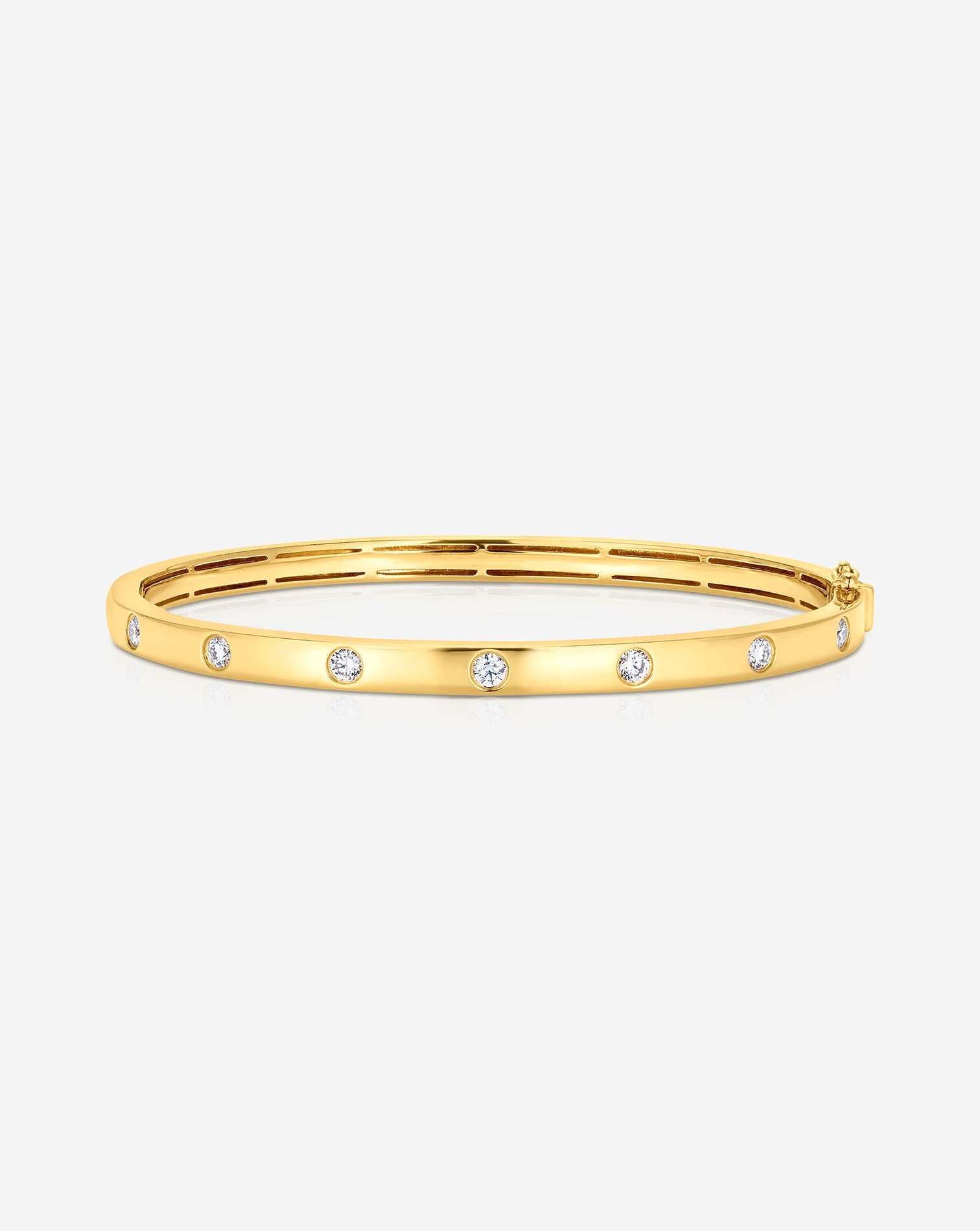 0.63CT lab diamond inlay bangle made in 9kt gold. The image shows te round diamonds being inlayed in a 9kt yellow gold bangle.