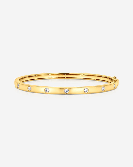 0.63CT lab diamond inlay bangle made in 9kt gold. The image shows te round diamonds being inlayed in a 9kt yellow gold bangle.