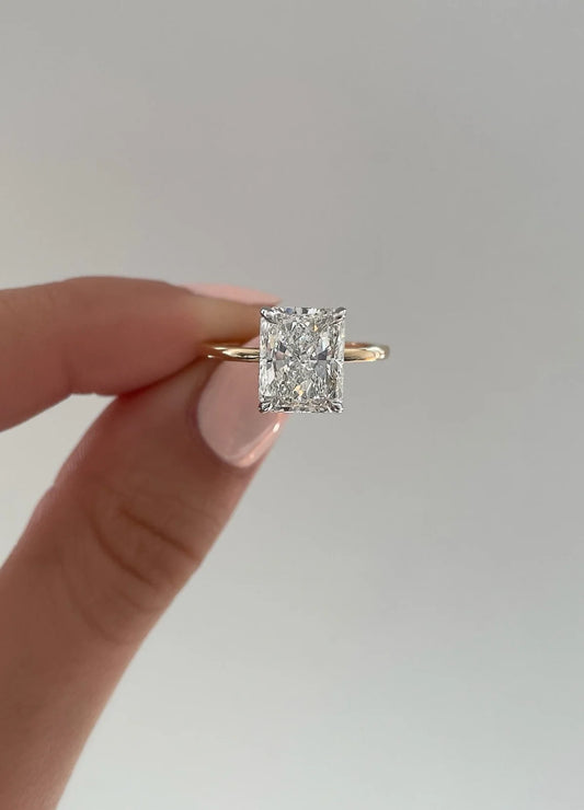 The image shows a close up of a 2.5ct radiant cut diamind ring showing the cut f the diamond and setting.