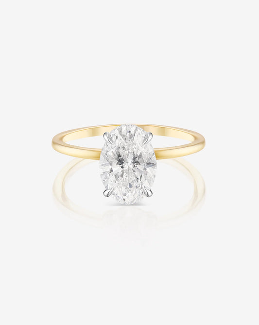 The image shows the front profile of a 2 carat oval shape lab diamond solitaire ring set in 14kt hallmark yellow gold band