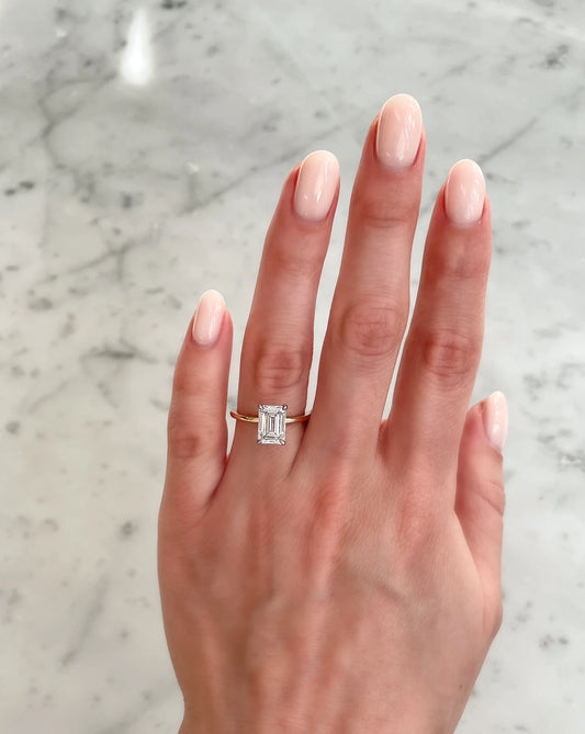 2 carat emerald cut lab diamond solitaire ring in 14kt hallmar  yellow gold band. The image shows how the ring looks when adorned.