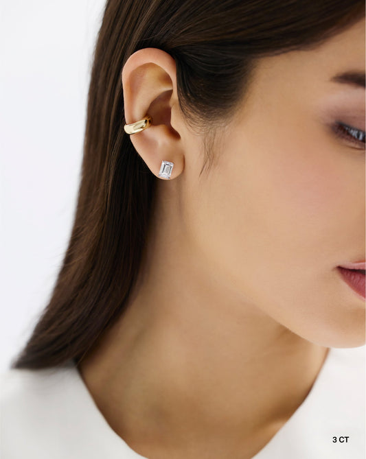 The image shows a woman wearing a 3 carat emerald cut lab diamond set in 14 carat white gold.