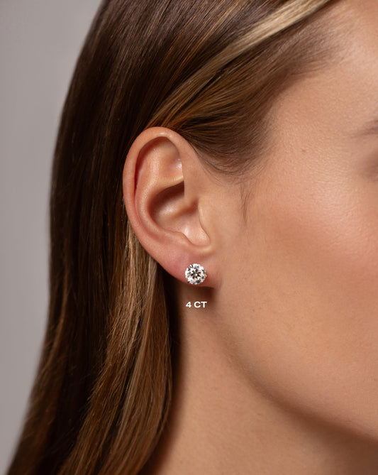 Woman wearing a round 4CT diamond stud earring made in white gold.