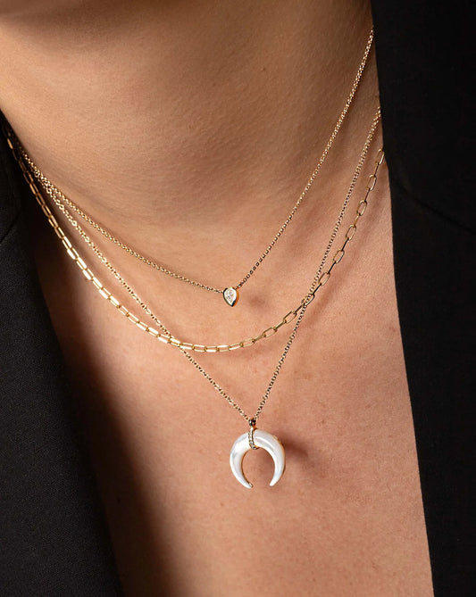 50 pointer pear shape lab diamond pendant in a 9kt hallmark yellow gold chain stacked/layered with other dainty pendants