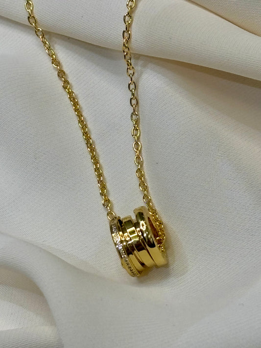 A circular pendant with moissanite pave setting on sides made with 92.5 Sterling silver with 18kt gold plating in a gold tone chain