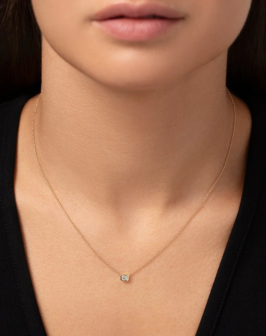 Half carat emerald shape, lab diamond pendant with bezel setting made in a 9 carat hallmark yellow gold chain.