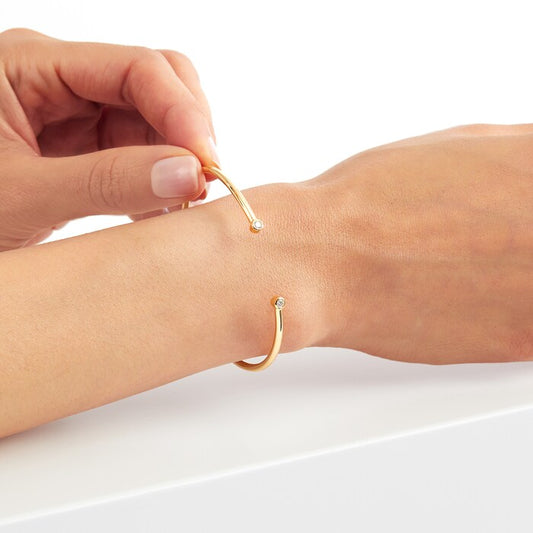 Lab diamond and 14kt hallmark yellow gold claw bangle bracelet on a hand