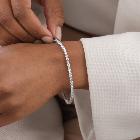 Sparkling 4.87 carat round shape lab diamond tennis bracelet set in 14kt white gold on a hand.